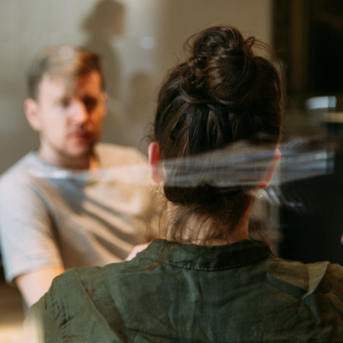 Two people seated across from each other in conversation, suggesting a one-to-one support or supervision meeting